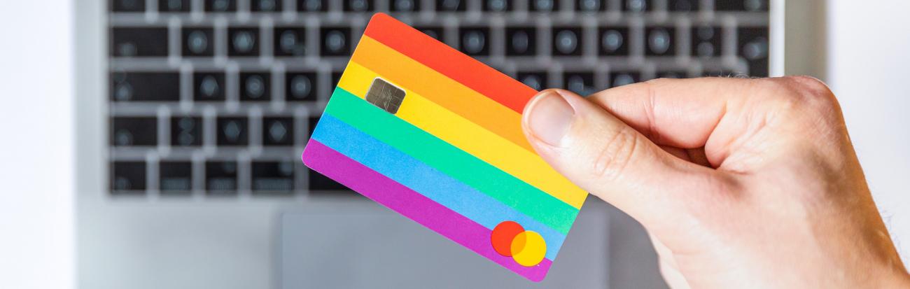 Insight image: multicoloured payment card, held over a laptop